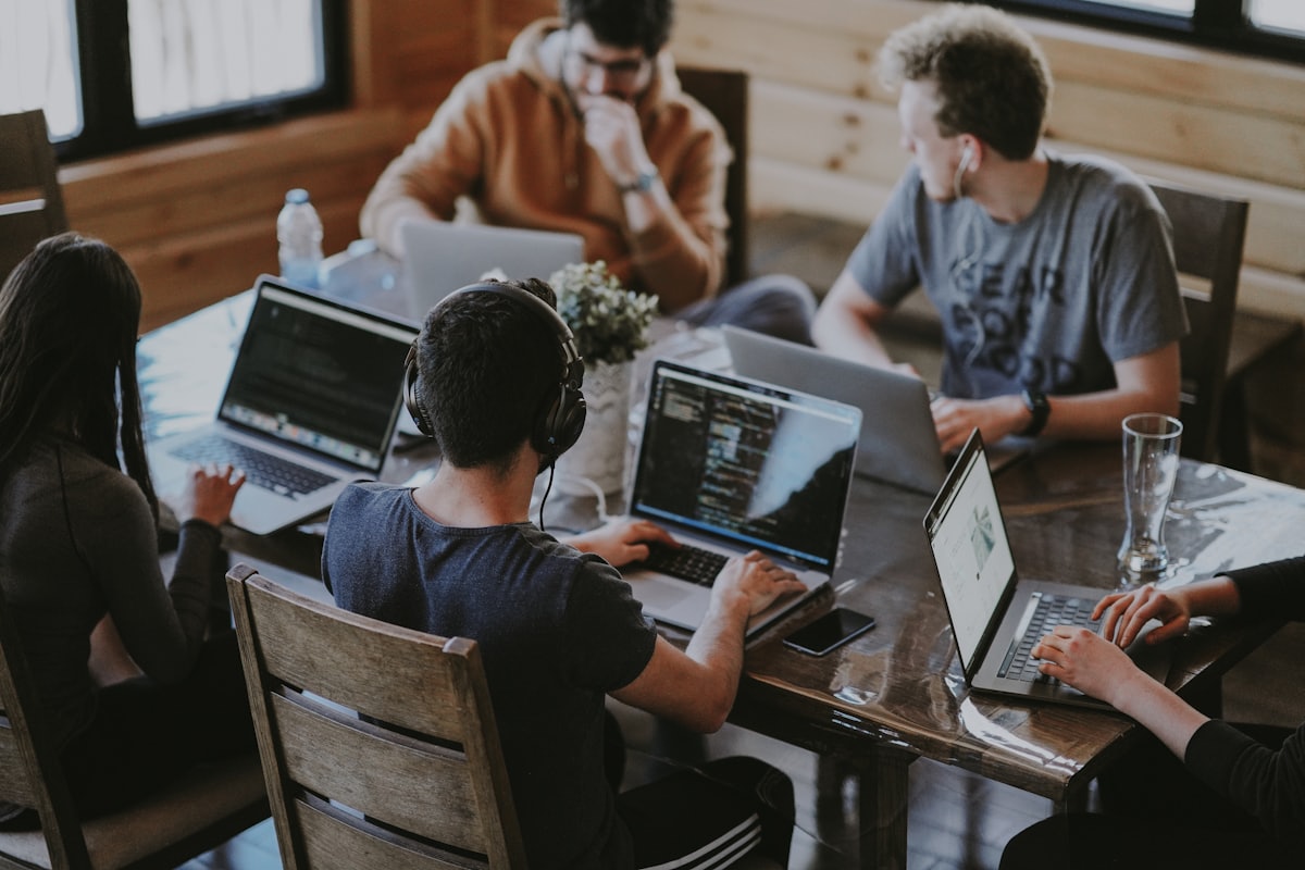 People working on laptops around a shared table